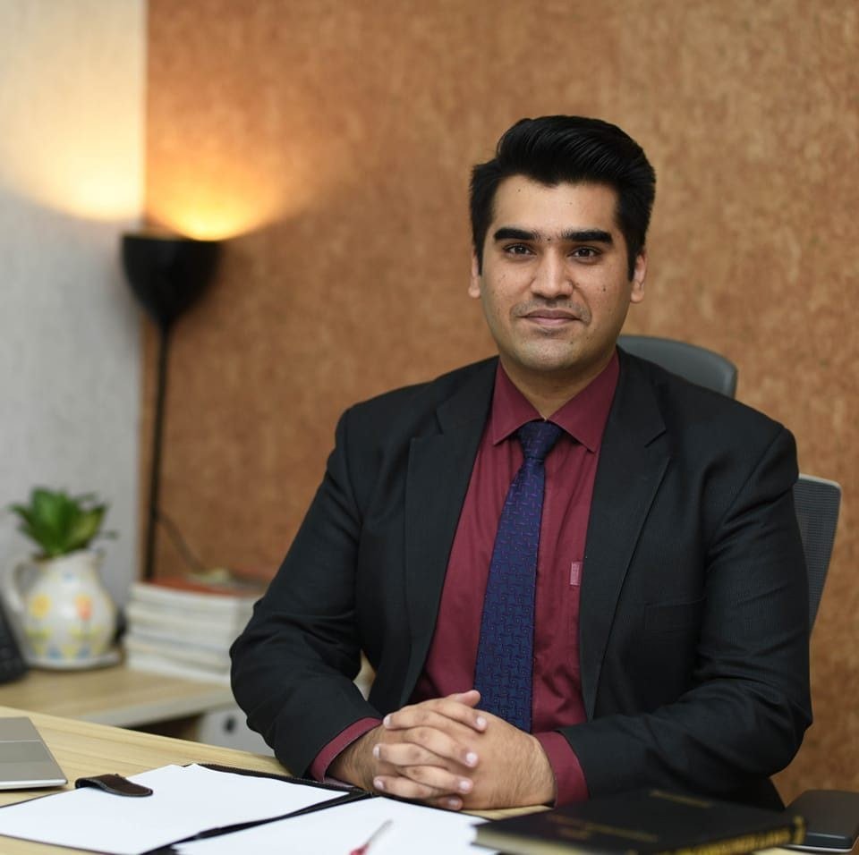 Muhammad Ali Aizaz seated in a professional office setting